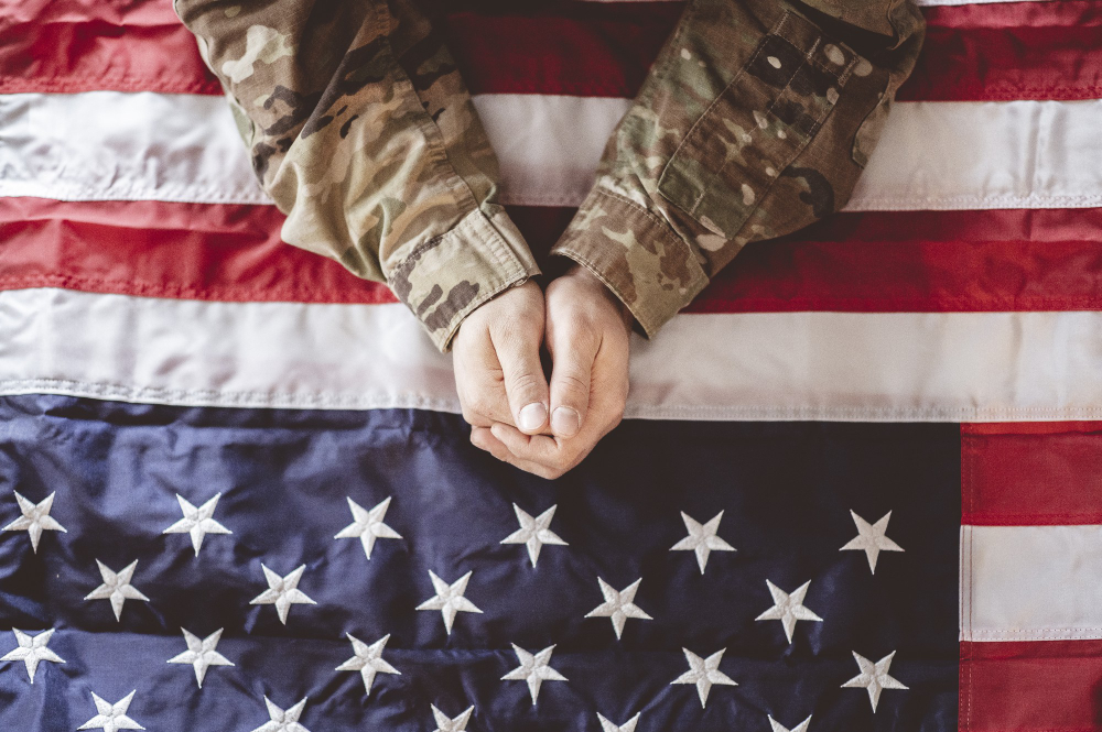 american-soldier-mourning-praying-with-american-flag-front-him